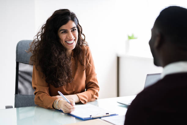 female manager interviewing a young male applicant in office